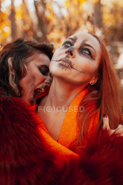 Woman with mouth open embracing friend during Halloween — Stock Photo