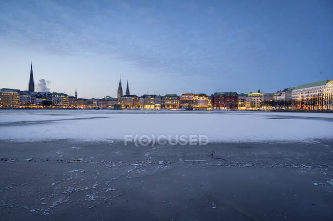 Allemagne, Hambourg, Surface gelée de l'intérieur du lac Alster à l'aube avec horizon de la ville en arrière-plan — Photo de stock
