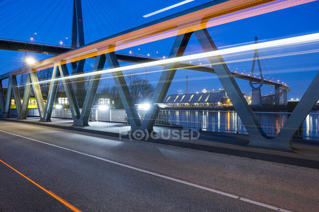 Alemanha, Hamburgo, Trilhas de luz para veículos na ponte Kohlbrand ao entardecer — Fotografia de Stock