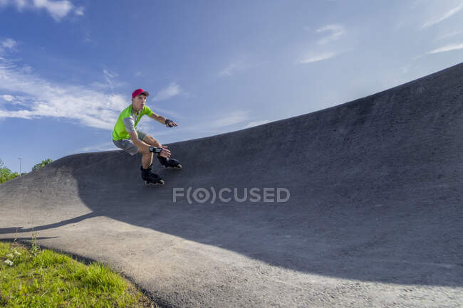 Atleta masculino patinando na pista da bomba durante o dia ensolarado — Fotografia de Stock