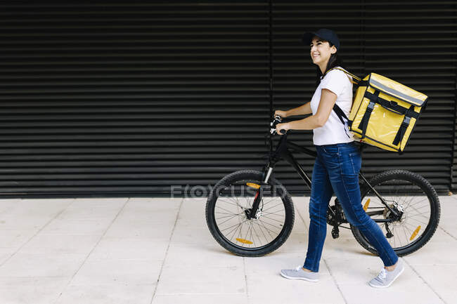 Sorrindo mulher de parto andando com bicicleta no caminho — Fotografia de Stock