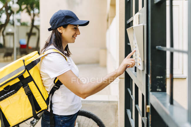Mulher de parto sorridente com porta de abertura de mochila — Fotografia de Stock