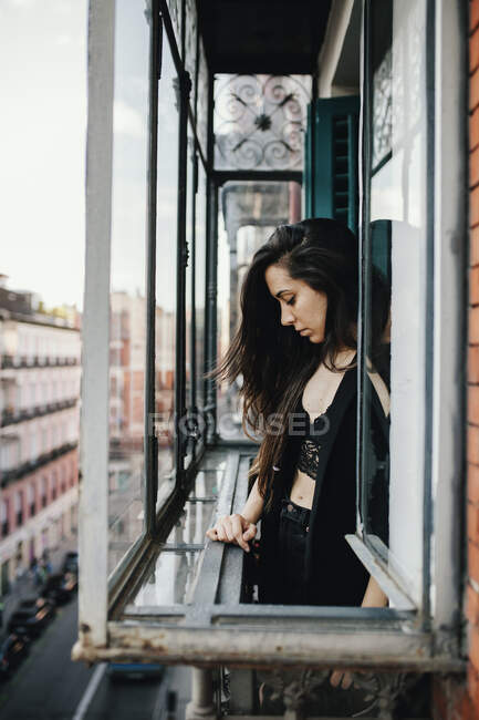 Traurige Frau steht am Fenster — Stockfoto