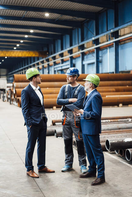 Profissionais de negócios do sexo masculino tendo discussão na indústria metalúrgica — Fotografia de Stock