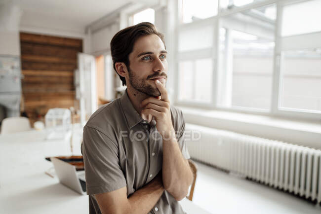 Чоловік з рукою на підборідді розмірковуючи вдома — стокове фото