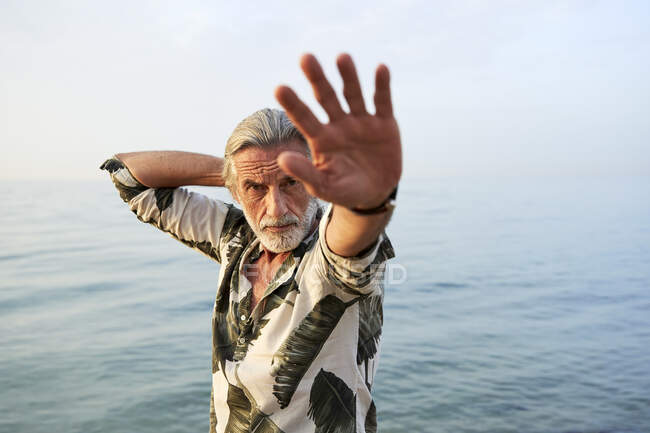 Homme gestuelle près de la mer à la plage — Photo de stock
