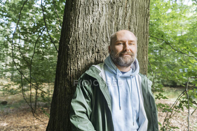 Бородатый человек стоит перед деревом — стоковое фото