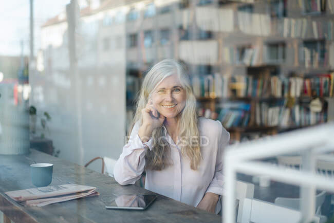 Sorridente donna d'affari guardando attraverso la finestra del caffè — Foto stock
