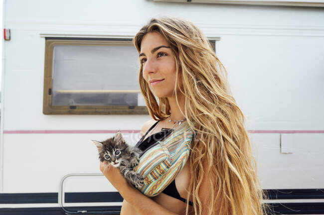 Femme réfléchie avec chaton dans le sac de taille — Photo de stock