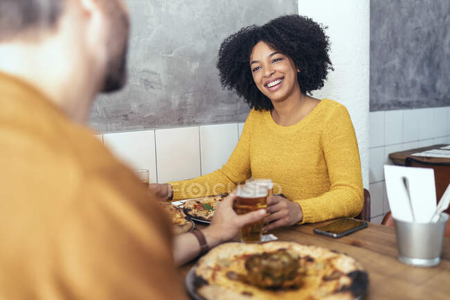 Bonne femme appréciant boire avec un ami masculin au restaurant — Photo de stock