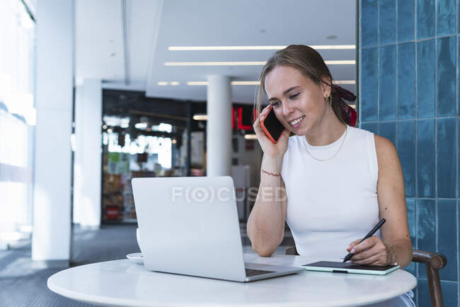 Grafikerin telefoniert in Coffeeshop mit Handy — Stockfoto