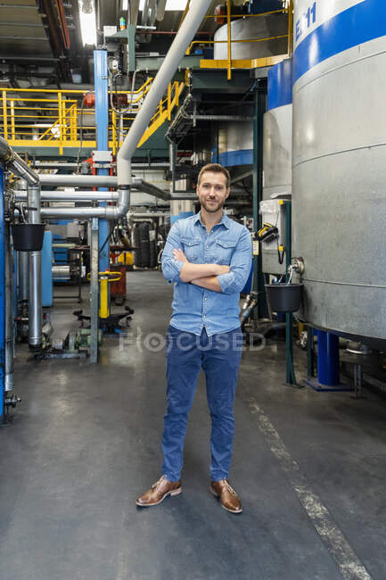 Businessman with arms crossed standing by large container — Stock Photo