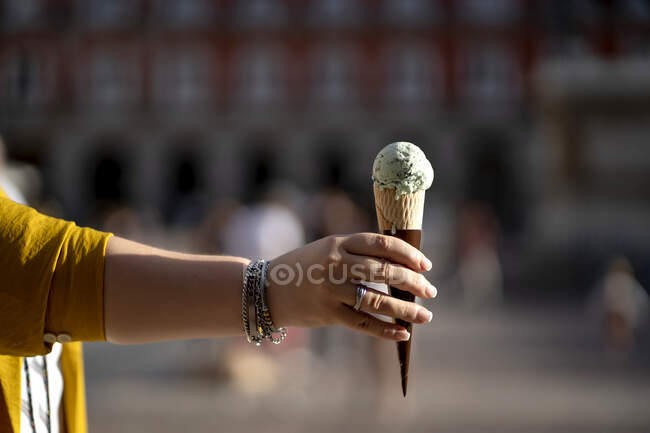 Mature woman holding ice cream cone — Stock Photo