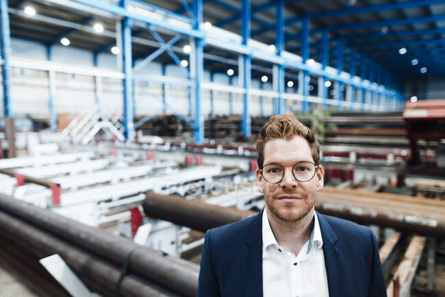 Homme professionnel aux cheveux bruns portant des lunettes en usine — Photo de stock