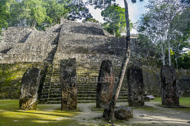 Mexico, Campeche, Menhirs standing in front of ancient Maya temple in Calakmul — Stock Photo
