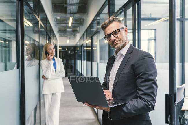 Professionnels masculins et féminins dans le couloir au bureau — Photo de stock