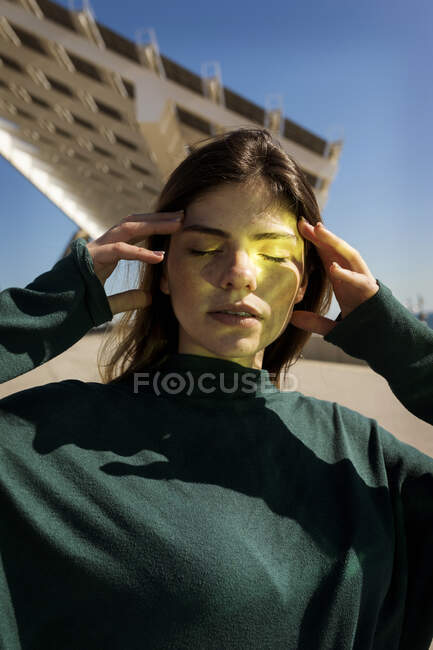 Mujer con reflejo de energía solar en la cara durante el día soleado - foto de stock