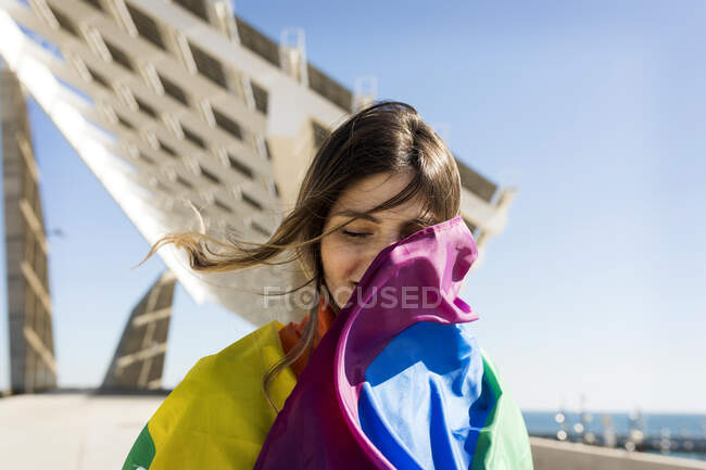 Жінка вкрита веселковим прапором під час сонячного дня — стокове фото