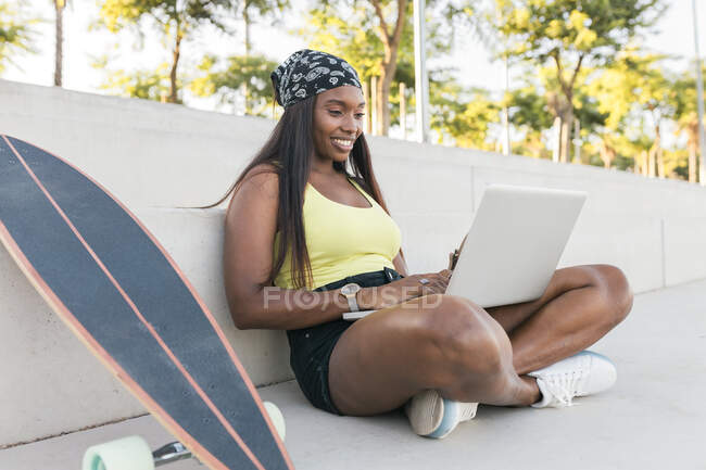 Женщина с ноутбуком, сидя скрестив ноги на тропинке — стоковое фото
