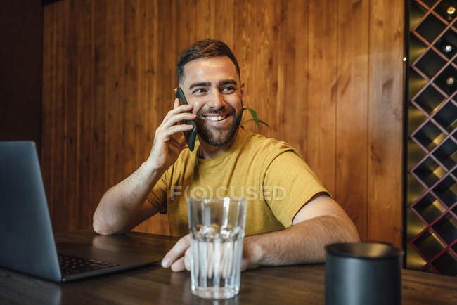 Beau professionnel masculin parlant sur téléphone mobile au bureau à la maison — Photo de stock