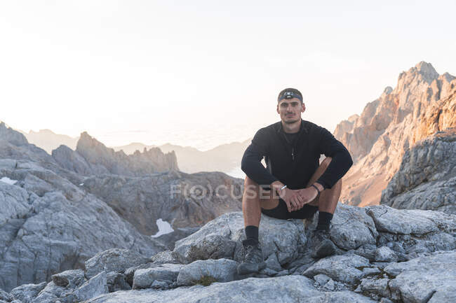 Giovane turista maschio seduto sulla roccia, Picos de Europe, Cantabria, Spagna — Foto stock