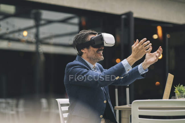Smiling businessman gesturing while using wearable computer at hotel — Stock Photo