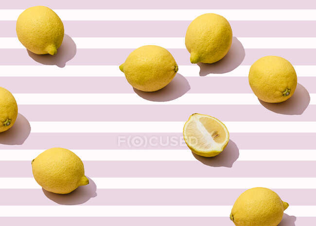 Fresh lemons against pink striped background — Stock Photo