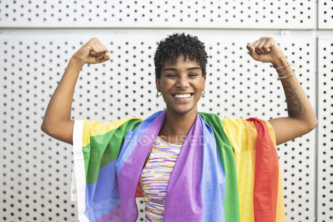 Glückliche lesbische Frau lässt vor Metallwand die Muskeln spielen — Stockfoto