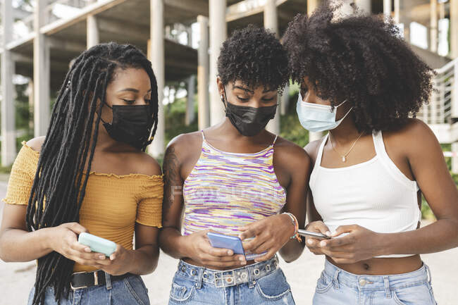 Junge Frau teilt während Pandemie Smartphone mit Freundinnen — Stockfoto