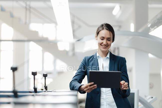 Profissional de negócios feminino usando tablet digital na indústria — Fotografia de Stock