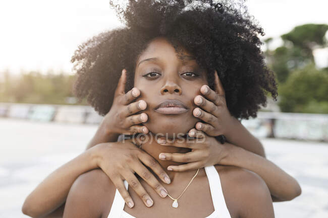 Mani che toccano il viso della donna afro — Foto stock