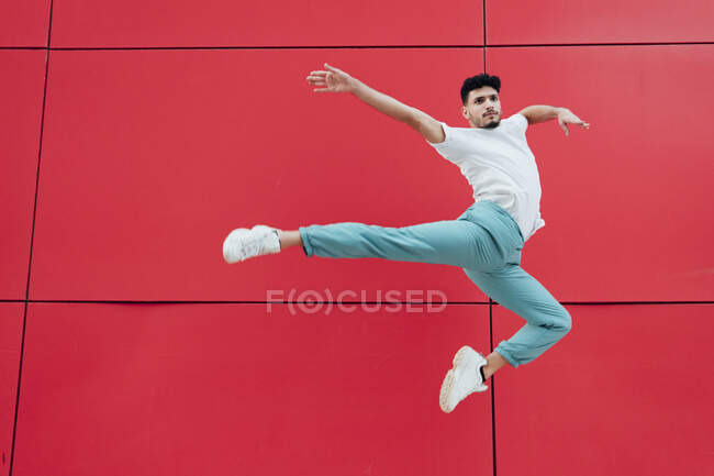 Ginnasta maschio che balla davanti al muro rosso — Foto stock