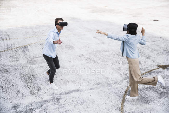 Male and female colleagues using virtual reality headset on rooftop — Stock Photo