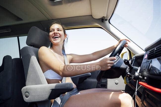 Веселая женщина среднего возраста за рулем фургона — стоковое фото