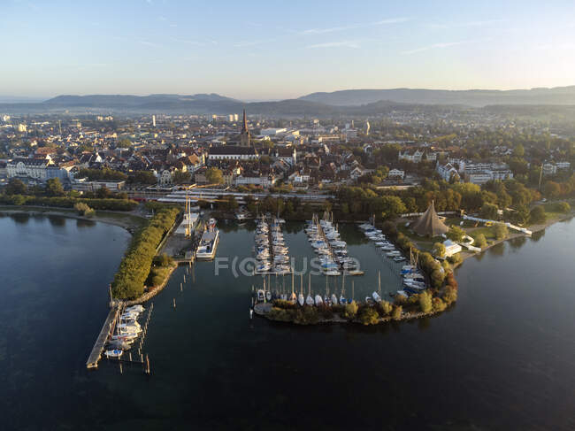 Germany, Baden-Wurttemberg, Radolfzell Am Bodensee, Aerial view of harbor of lakeshore town at dawn — Stock Photo