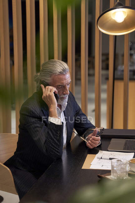 Мужчина-бизнесмен разговаривает по мобильному телефону в отеле — стоковое фото