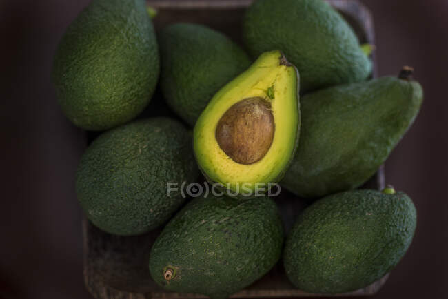 Авокадо в корзине на столе — стоковое фото