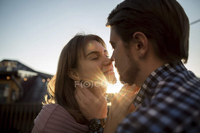 Young couple kissing each other during sunset — Stock Photo