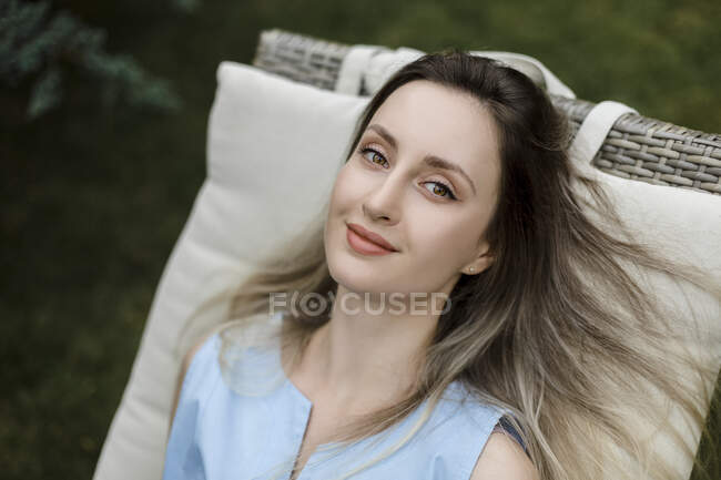 Young woman lying on deck chair in garden — Stock Photo