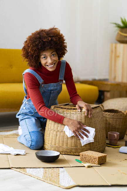Рыжая женщина убирает плетеную корзину в гостиной — стоковое фото