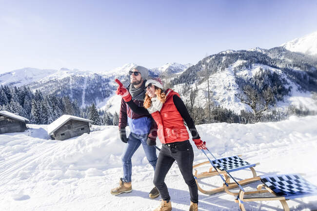 Женщина указывает на то, что мужчина держит сапожник на снегу — стоковое фото