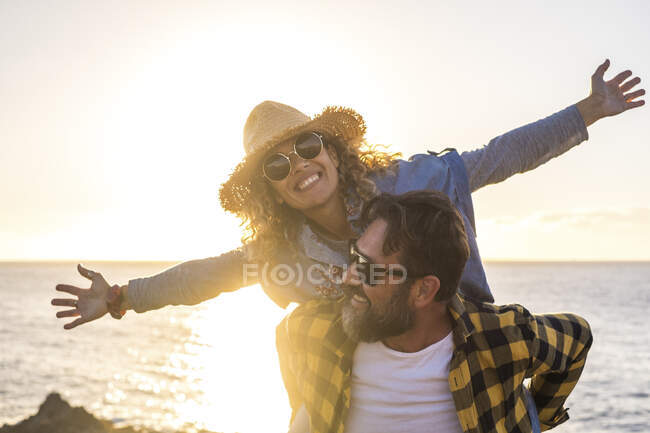Alegre casal se divertindo na praia durante o dia ensolarado — Fotografia de Stock