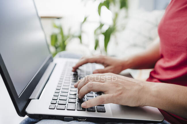 Mulher digitando ao usar laptop em casa — Fotografia de Stock