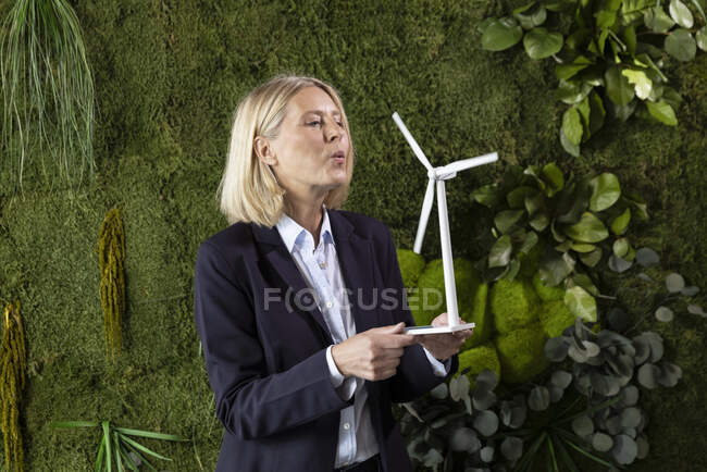 Modello di turbina eolica soffiante professionale femminile davanti alle piante — Foto stock