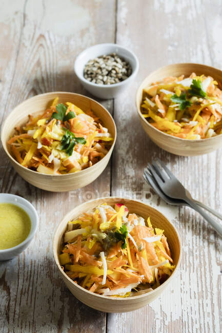 Three bowls of grated salad with sweet potatoes and parsnips — Stock Photo