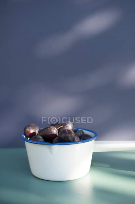 Saucepan with freshly picked plums — Stock Photo