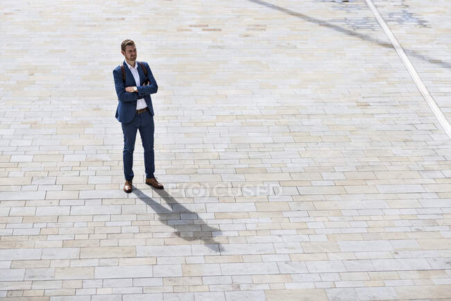 Jeune homme d'affaires les bras croisés debout sur le sentier — Photo de stock