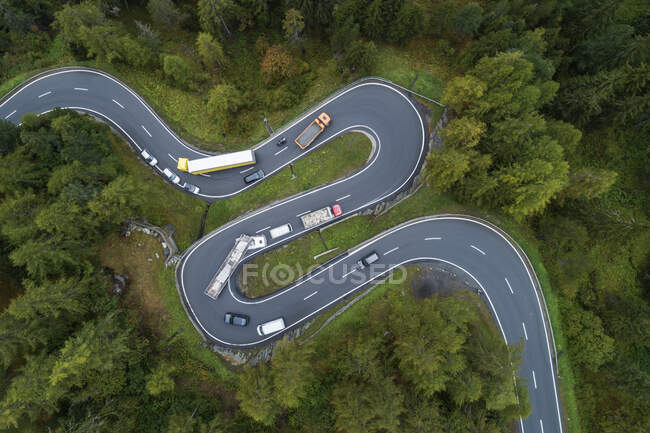 Drone vista de los coches que conducen a lo largo de sinuoso camino Maloja Pass - foto de stock