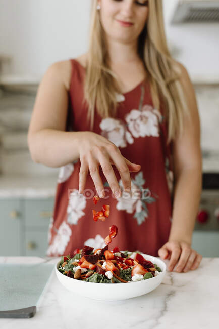 Giovane piatto di guarnitura professionale femminile con fragola tritata in cucina — Foto stock