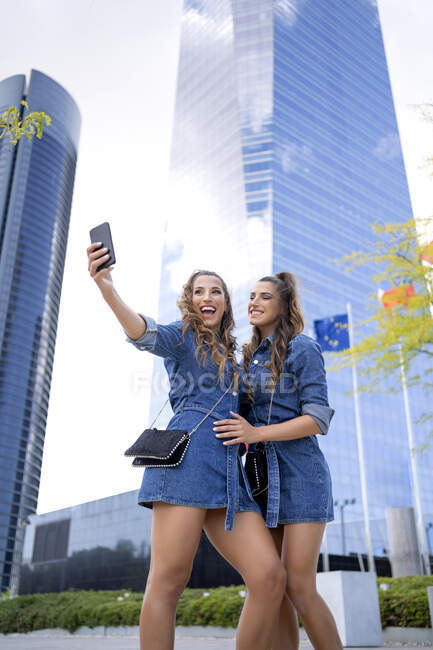 Soeur joyeuse prendre selfie par téléphone intelligent en ville — Photo de stock